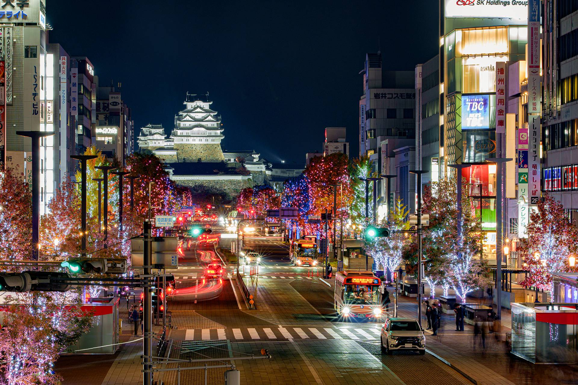 夜の姫路駅前。イルミネーションの大手前通りの先に、ライトアップされた姫路城が見える。